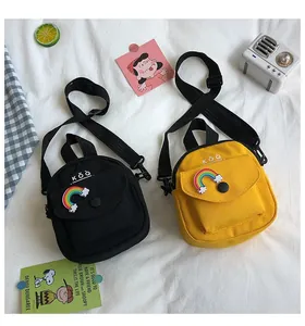 Detailed top view of black and yellow canvas crossbody bags with rainbow patches