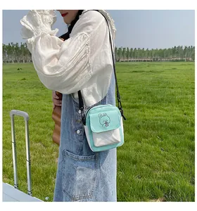 Detail of mint green canvas crossbody bag with cute rabbit pattern for casual outdoor use