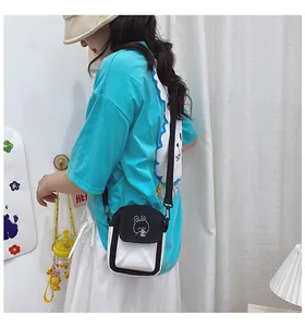 Detail of a small canvas crossbody bag featuring a cute black cartoon bunny embroidery