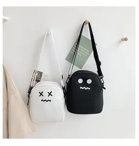 Detail of cute cartoon mini crossbody bags in black and white with adjustable straps