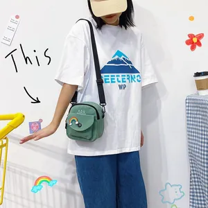 Green canvas crossbody small bag with rainbow patch and adjustable black shoulder strap