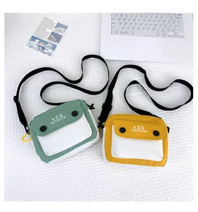 Detail of canvas crossbody bags in green and yellow with adjustable straps and logo