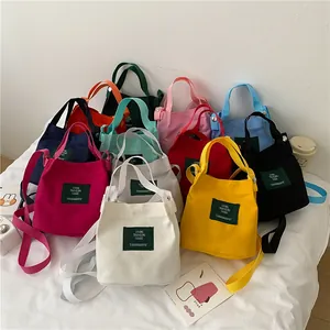 Versatile canvas tote and crossbody bags in multiple colors with woven logo labels