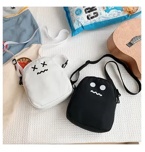 Detailed view of black and white canvas crossbody bags with cute cartoon emoji design