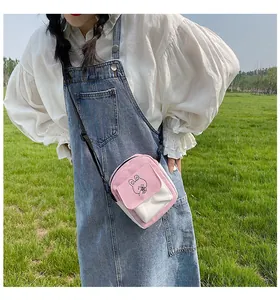 Outdoor close-up of a pink and white canvas crossbody bag with a cute rabbit illustration