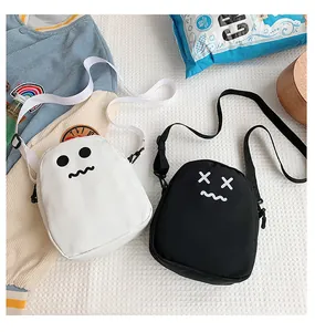 Flat lay of black and white mini crossbody bags with cartoon expressions and nylon straps