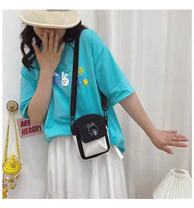 Close-up of a stylish canvas crossbody bag featuring a cute bunny embroidery patch on the flap