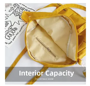 Interior view of yellow canvas bag showing spacious main compartment and zipper pocket