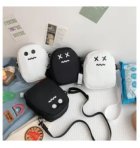 Detailed view of mini canvas crossbody bags featuring creative ghost face prints in black and white