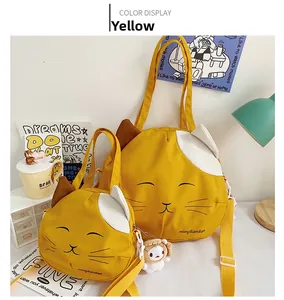 Detail of yellow cat-shaped canvas bag set with 3D ears and cute smiling face