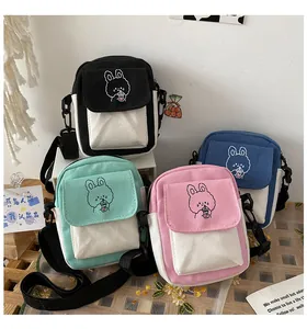 Detailed macro view of small canvas crossbody bags in four colors with bunny embroidery