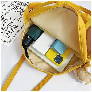 Top view of yellow canvas tote bag showing spacious interior with umbrella and notebook