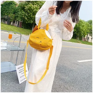 Detail of a bright yellow cat-shaped canvas bag with 3D ears and long shoulder strap