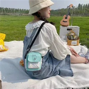 Mini mint green canvas crossbody bag with cartoon bear illustration and adjustable strap