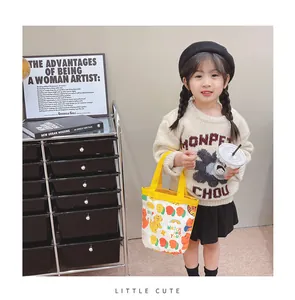 Detail of cute canvas bucket bag with cartoon tiger and yellow handles on child model
