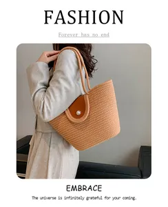 Détail du sac fourre-tout tissé avec rabat en cuir et fermeture bouton perle élégante