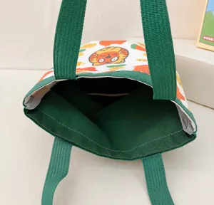 Detalle de la estructura interna y el forro verde del bolso tipo cubo de lona de algodón