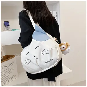 Detail of white cat-themed canvas bag with blue cat ears and a plush sheep charm
