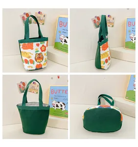 Detail view of canvas bucket bag with green handles and cute cartoon animal prints