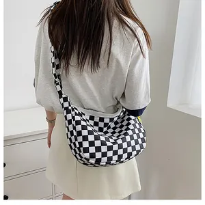 Detailansicht der schwarz-weiß karierten Canvas Hobo Bag über der Schulter getragen