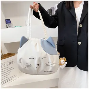 Detail of cute cat face white canvas tote bag with blue ears and fluffy sheep keychain