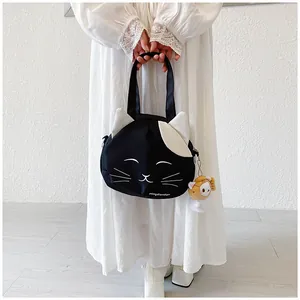 Detail of cute black and white cat canvas tote bag with matching plush pendant and shoulder strap
