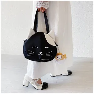Detail of cute cat canvas tote bag featuring 3D ears and a plush cartoon charm
