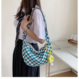 Detail der türkis karierten Canvas-Tasche mit süßem Blumenanhänger für Damen