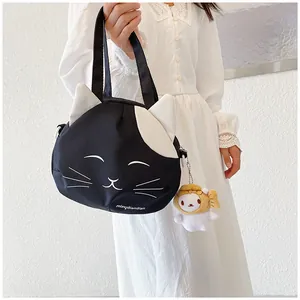 Detail of cute cat-shaped canvas bag with white ears and a plush rabbit charm