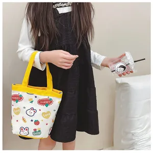 Detail of cute canvas bucket bag with rabbit and strawberry patterns for children