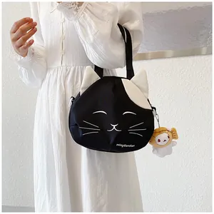 Close-up of black cat canvas bag featuring cute cat ears and a plush rabbit charm accessory