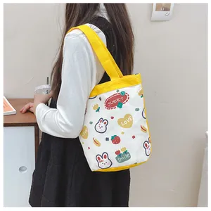Detail of cute canvas tote bag with yellow straps and sweet bunny strawberry prints