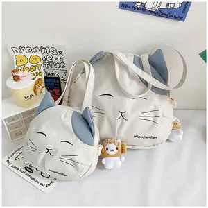 Detail of cat canvas tote bag set with cute feline embroidery and plush charm accessory