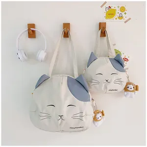 Detail of cute cat canvas bags with 3D ears and adorable plush charms hanging on wooden hooks
