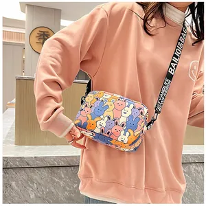 Detailed view of casual crossbody bag with rabbit print and letter canvas strap on model