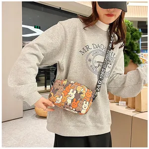 Detail of cartoon rabbit print crossbody bag with wide letter canvas shoulder strap