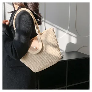 Vue détaillée du sac seau tissé avec texture en corde beige et fermoir perle élégant