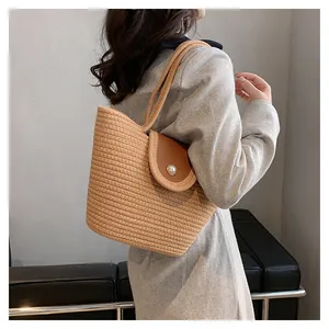 Détail du sac cabas en paille tissé main avec rabat en cuir et fermoir perle élégant