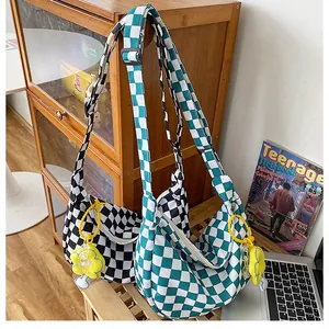 Detail der karierten Hobo-Canvas-Taschen in Schwarz und Grün mit Sonnenblumen-Anhänger