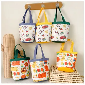 Detailed view of six mini canvas lunch bags with various cute cartoon patterns and handles