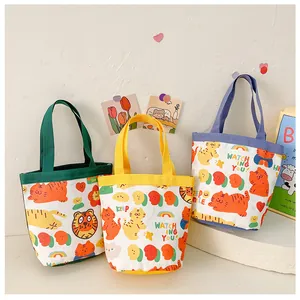 Detailed view of three canvas lunch bags with colorful straps and cute cartoon animal prints