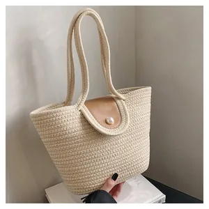 Détail du sac cabas tissé avec rabat en cuir et fermeture bouton perle nacrée