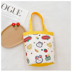 Close-up of cute cartoon canvas tote bag with rabbit and strawberry prints on white background