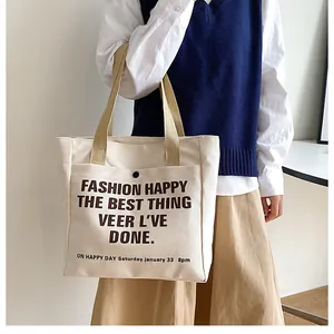 Detail of beige canvas tote bag showing thick fabric texture and brown webbing handle