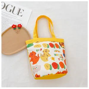 Detailed macro of cream canvas tote bag with cute yellow cat print and woven handles