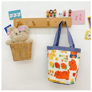 Detail view of the cute cartoon tiger canvas tote bag hanging in a cozy room setting