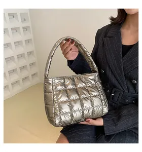 Primer plano detallado de un bolso tote plateado acolchado con acabado metálico brillante