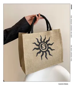 Detalle del bolso tote de lona con gráfico solar y asas de cuerda trenzada negra