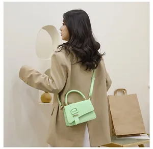 Detail van de muntgroene crossbodytas met leertextuur en vierkante gespversiering