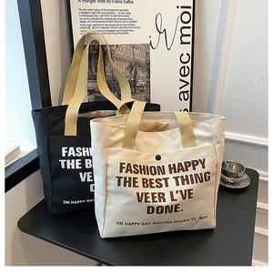 Close-up of black and cream canvas tote bags featuring front snap pockets for daily commuting